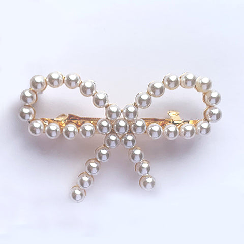 Bow shaped hair clip in gold with small pearls
