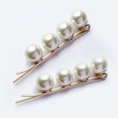 Pair of gold hair pins with a row of four pearls